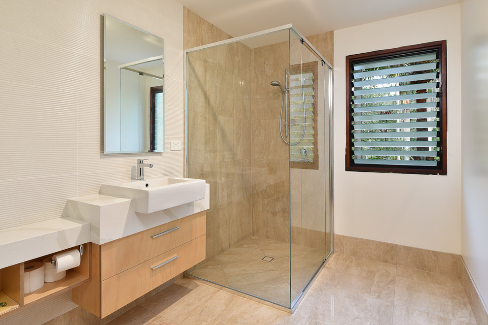 Immagine di una grande stanza da bagno tropicale con ante lisce, ante in legno chiaro, doccia ad angolo, piastrelle multicolore, pareti bianche, lavabo da incasso e porta doccia a battente