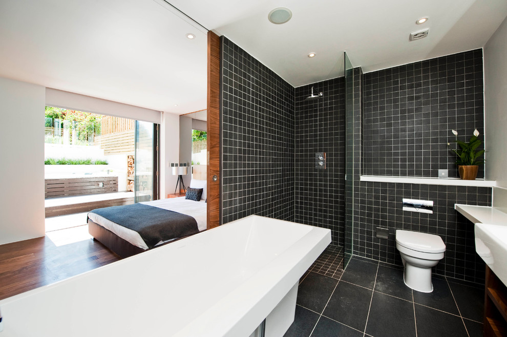 Modelo de cuarto de baño moderno con ducha a ras de suelo, lavabo sobreencimera y encimeras blancas