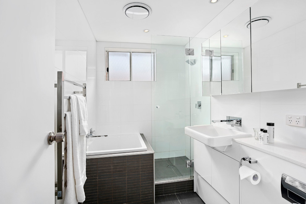 Kleines Modernes Badezimmer En Suite mit weißen Schränken, Toilette mit Aufsatzspülkasten, schwarzen Fliesen, Keramikfliesen, weißer Wandfarbe, Keramikboden, Waschtischkonsole, Quarzwerkstein-Waschtisch, Eckbadewanne und Eckdusche in Sydney
