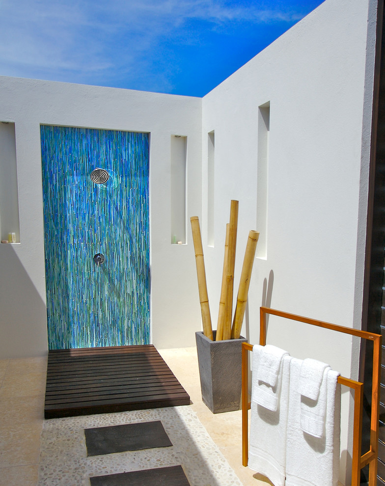 Exemple d'une salle de bain principale exotique en bois foncé de taille moyenne avec un lavabo de ferme, un placard à porte plane, un plan de toilette en bois, une douche ouverte, WC séparés, un carrelage bleu, un carrelage en pâte de verre, un mur blanc et un sol en galet.