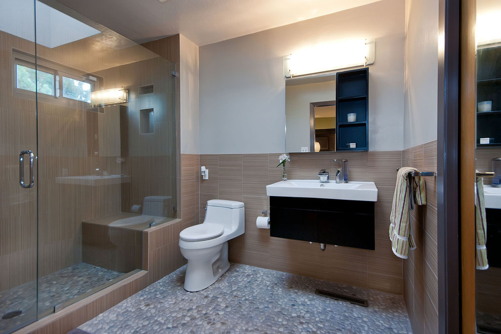 На фото: ванная комната в современном стиле с монолитной раковиной и полом из галечной плитки