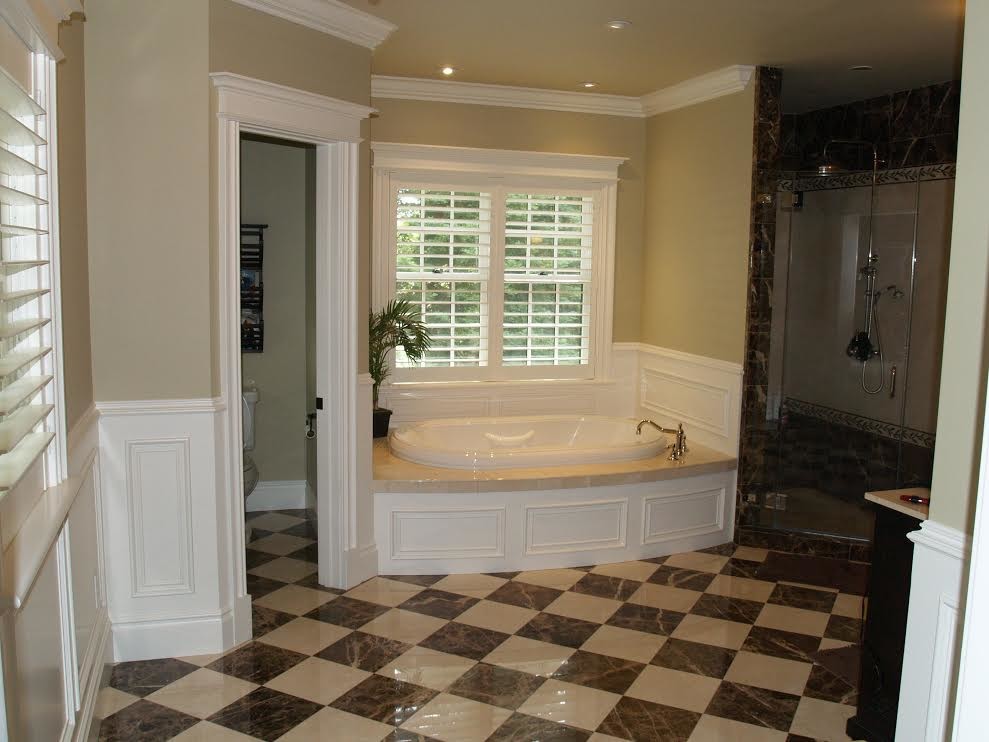 Стильный дизайн: большая главная ванная комната в классическом стиле с искусственно-состаренными фасадами, ванной в нише, душем в нише, коричневой плиткой, каменной плиткой, бежевыми стенами, мраморным полом, врезной раковиной, столешницей из искусственного кварца, разноцветным полом и душем с распашными дверями - последний тренд