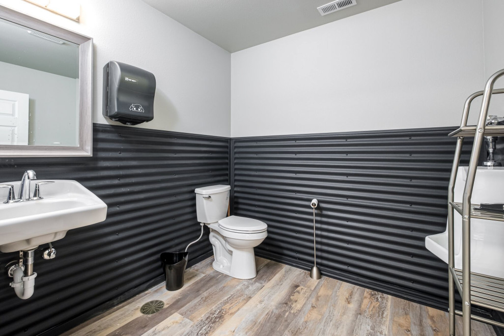 Diseño de cuarto de baño urbano de tamaño medio con urinario, baldosas y/o azulejos de metal, suelo laminado, lavabo suspendido y suelo beige