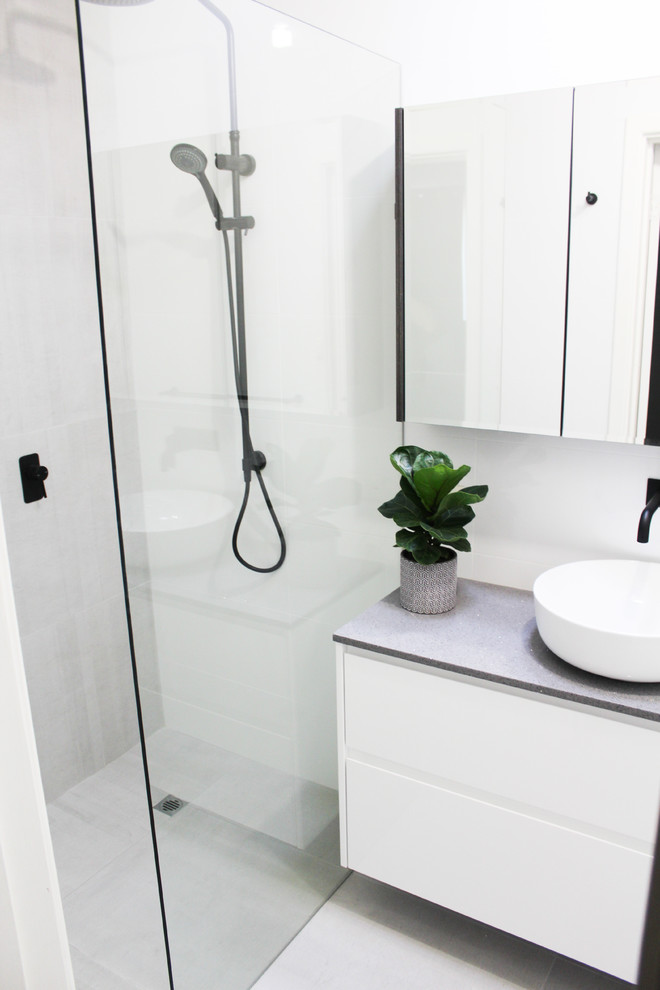 Example of a small minimalist 3/4 gray tile and porcelain tile porcelain tile and gray floor bathroom design in Perth with flat-panel cabinets, white cabinets, a one-piece toilet, gray walls, a vessel sink, solid surface countertops and gray countertops