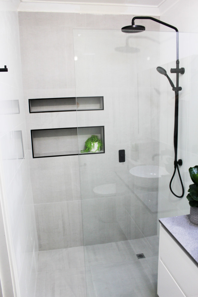 Источник вдохновения для домашнего уюта: маленькая ванная комната в стиле модернизм с плоскими фасадами, белыми фасадами, открытым душем, унитазом-моноблоком, серой плиткой, керамогранитной плиткой, серыми стенами, полом из керамогранита, душевой кабиной, настольной раковиной, столешницей из искусственного камня, серым полом, открытым душем и серой столешницей для на участке и в саду