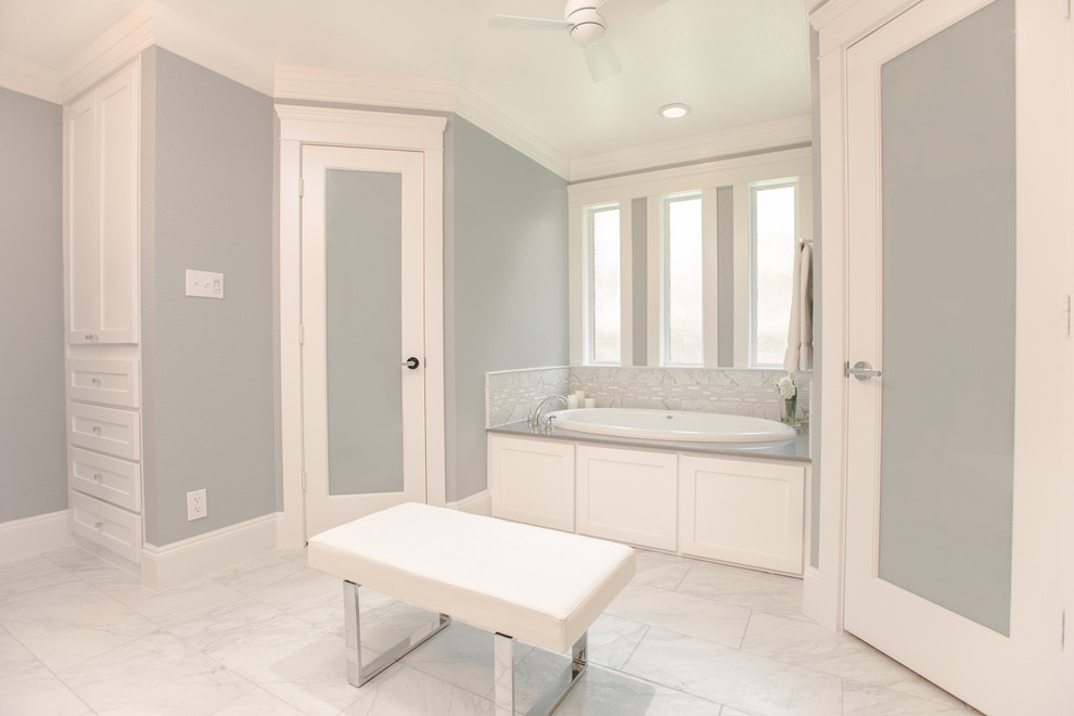 Corner shower - mid-sized transitional master gray tile corner shower idea in Dallas with a vessel sink, recessed-panel cabinets, white cabinets, quartzite countertops, a one-piece toilet and gray walls