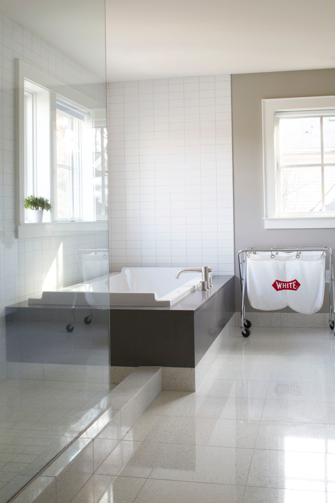 Idée de décoration pour une grande salle de bain principale et grise et blanche minimaliste avec une baignoire posée, une douche d'angle, un mur beige et une fenêtre.