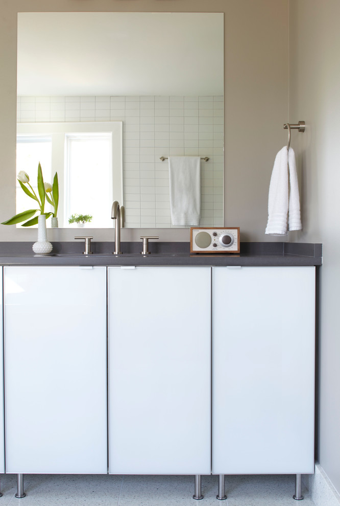 На фото: ванная комната в стиле модернизм с плоскими фасадами, белыми фасадами и бежевой плиткой с