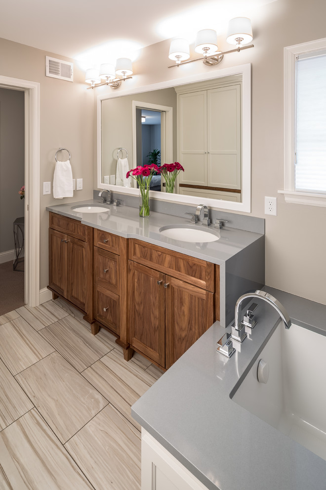 Example of a classic porcelain tile bathroom design in Minneapolis with an undermount sink, medium tone wood cabinets, quartz countertops, an undermount tub, beige walls, gray countertops and shaker cabinets