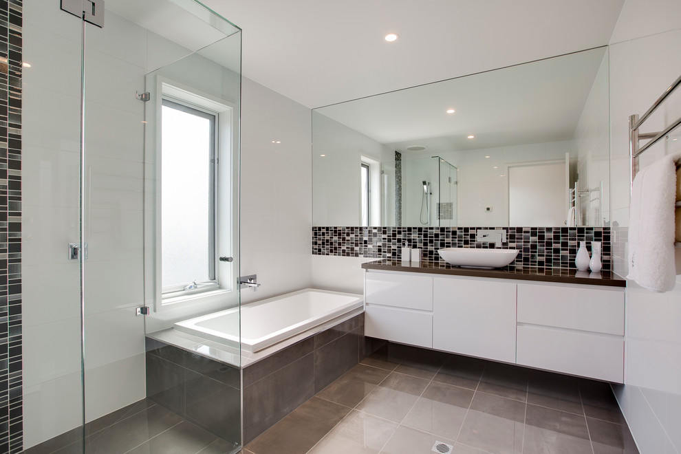 Immagine di una stanza da bagno contemporanea con lavabo a bacinella e vasca da incasso