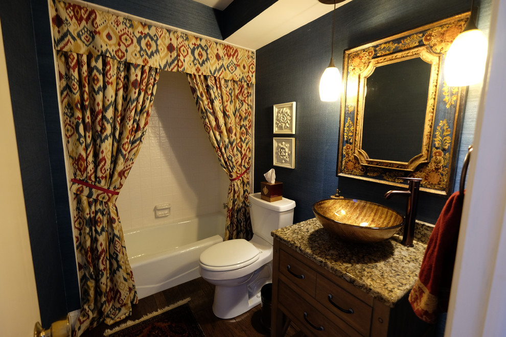 Inredning av ett eklektiskt litet badrum med dusch, med skåp i shakerstil, skåp i mörkt trä, ett badkar i en alkov, en dusch/badkar-kombination, en toalettstol med separat cisternkåpa, blå väggar, mörkt trägolv, ett fristående handfat och granitbänkskiva