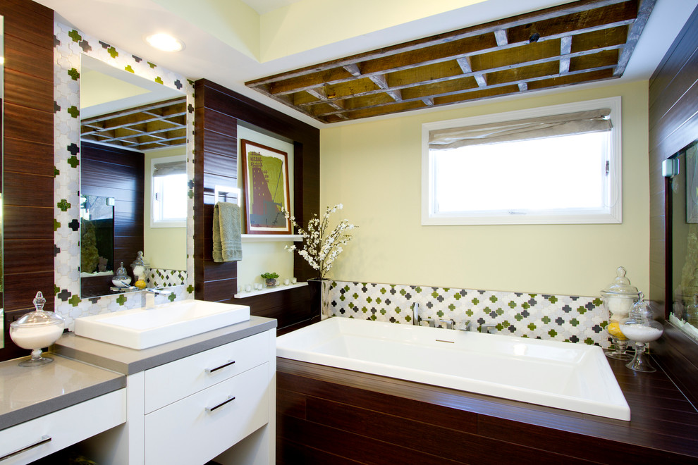 Пример оригинального дизайна: большая главная ванная комната в современном стиле с плиткой мозаикой, настольной раковиной, плоскими фасадами, белыми фасадами, накладной ванной, душем в нише, унитазом-моноблоком, разноцветной плиткой, белыми стенами, полом из керамогранита, столешницей из кварцита и серой столешницей
