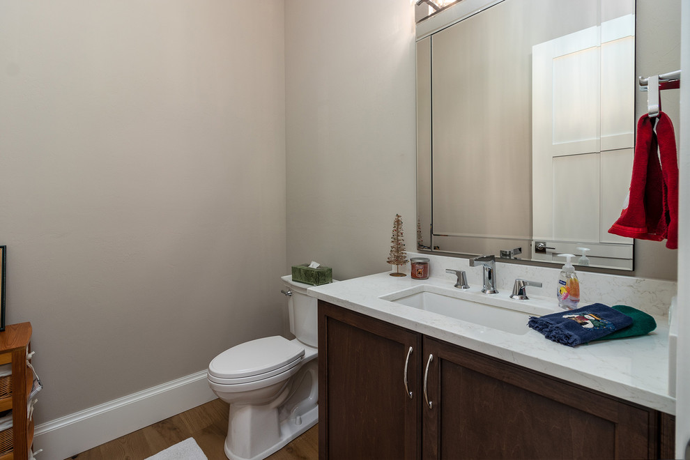 Ispirazione per una stanza da bagno tradizionale di medie dimensioni con ante in stile shaker, ante marroni, WC monopezzo, pareti beige, lavabo sottopiano, pavimento marrone e top bianco