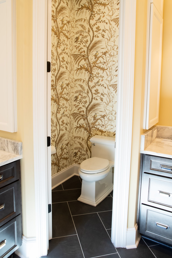 Пример оригинального дизайна: главная ванная комната среднего размера с фасадами с утопленной филенкой, встроенной тумбой, черными фасадами, ванной в нише, душем в нише, раздельным унитазом, желтыми стенами, полом из керамической плитки, столешницей из кварцита, черным полом, душем с распашными дверями, тумбой под одну раковину и разноцветной столешницей