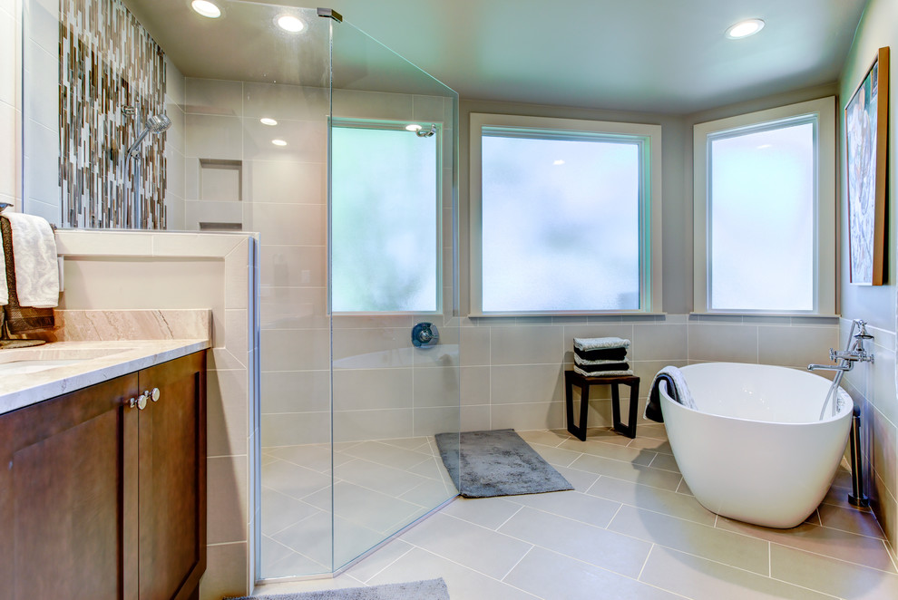 Example of a mid-sized transitional master beige tile, white tile and marble tile ceramic tile bathroom design in Raleigh with raised-panel cabinets, dark wood cabinets, a one-piece toilet, beige walls, a drop-in sink and marble countertops