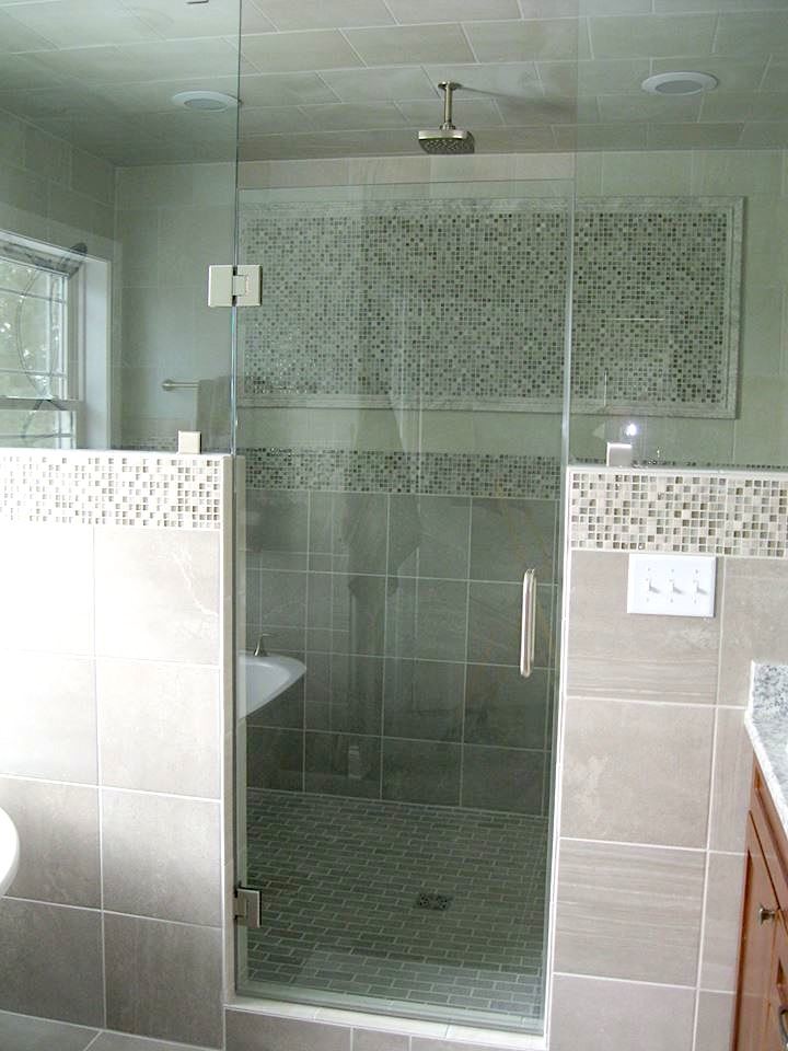 Design ideas for a large contemporary ensuite bathroom in Milwaukee with a freestanding bath, an alcove shower, grey tiles, stone tiles, grey walls, porcelain flooring, grey floors, a hinged door, recessed-panel cabinets, medium wood cabinets, a submerged sink and engineered stone worktops.