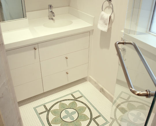 Inspiration för mellanstora klassiska vitt badrum med dusch, med släta luckor, vita skåp, en dusch i en alkov, en toalettstol med hel cisternkåpa, vita väggar, mosaikgolv, ett undermonterad handfat, bänkskiva i akrylsten, flerfärgat golv och dusch med gångjärnsdörr