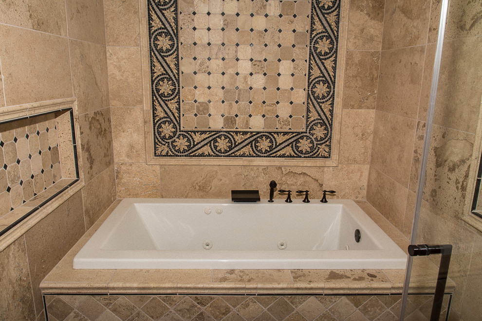 Modelo de cuarto de baño principal clásico grande con bañera encastrada, ducha abierta, sanitario de una pieza, baldosas y/o azulejos de piedra, paredes beige, suelo de travertino, lavabo integrado y encimera de madera