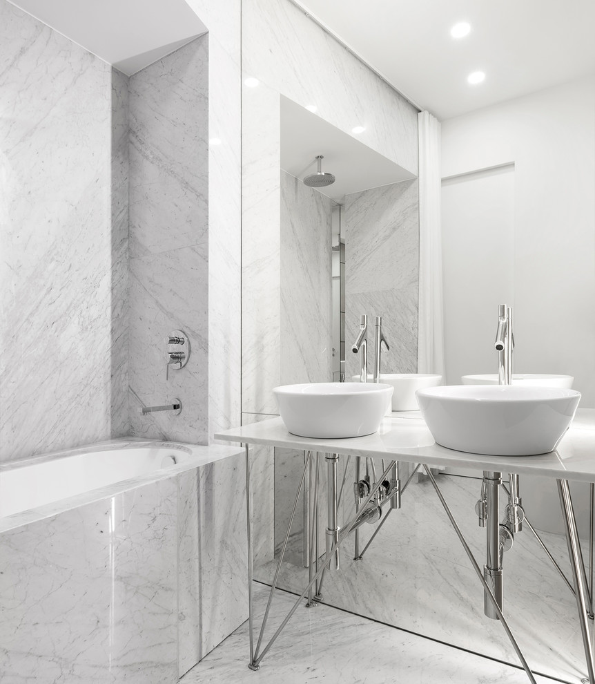 На фото: главная ванная комната в современном стиле с ванной в нише, настольной раковиной и белой столешницей
