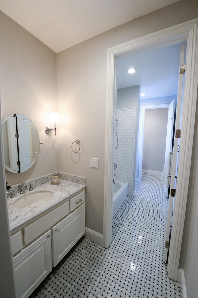 Inredning av ett klassiskt stort en-suite badrum, med klinkergolv i porslin, luckor med upphöjd panel, vita skåp, ett badkar i en alkov, en dusch/badkar-kombination, vit kakel, tunnelbanekakel, grå väggar, ett undermonterad handfat, marmorbänkskiva, flerfärgat golv och dusch med duschdraperi