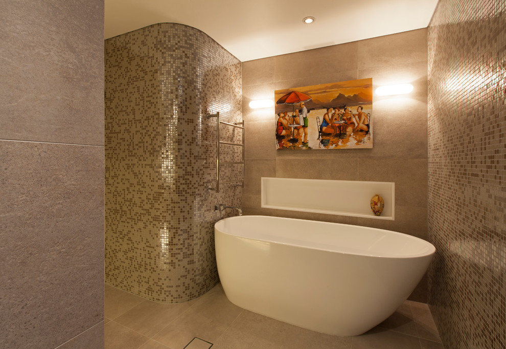 Свежая идея для дизайна: большая главная ванная комната в стиле модернизм с фасадами островного типа, светлыми деревянными фасадами, отдельно стоящей ванной, угловым душем, унитазом-моноблоком, бежевой плиткой, плиткой мозаикой, бежевыми стенами, полом из цементной плитки, настольной раковиной, столешницей из искусственного камня, серым полом, душем с распашными дверями, белой столешницей, акцентной стеной, тумбой под одну раковину, встроенной тумбой и кессонным потолком - отличное фото интерьера