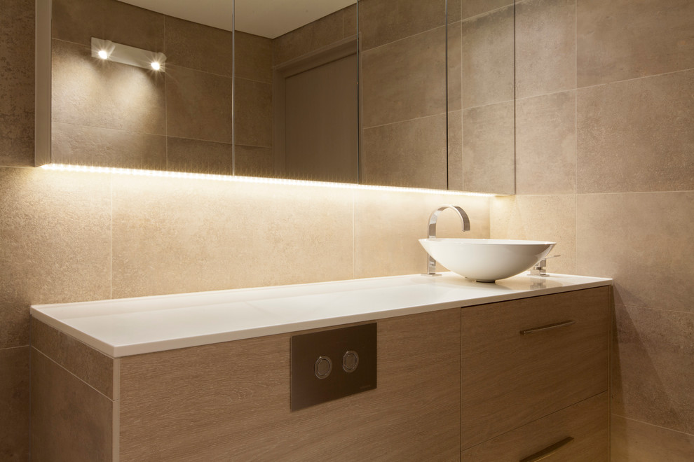 Example of a large minimalist master beige tile and mosaic tile cement tile floor, gray floor, single-sink and coffered ceiling bathroom design in Sydney with light wood cabinets, furniture-like cabinets, a one-piece toilet, beige walls, a vessel sink, solid surface countertops, a hinged shower door, white countertops and a built-in vanity