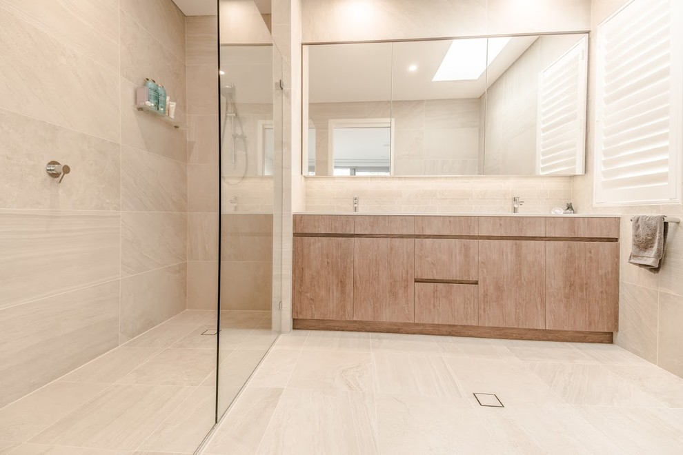 Diseño de cuarto de baño contemporáneo con armarios con paneles lisos, puertas de armario de madera clara, baldosas y/o azulejos beige, baldosas y/o azulejos marrones, baldosas y/o azulejos blancos y lavabo bajoencimera