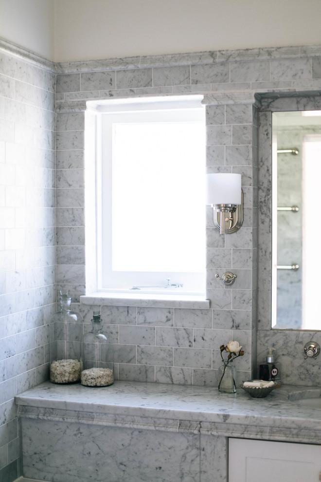 Esempio di una stanza da bagno tradizionale di medie dimensioni con vasca da incasso, piastrelle grigie, pareti grigie, lavabo integrato, porta doccia a battente, top grigio, piastrelle di marmo, pavimento in marmo e top in marmo