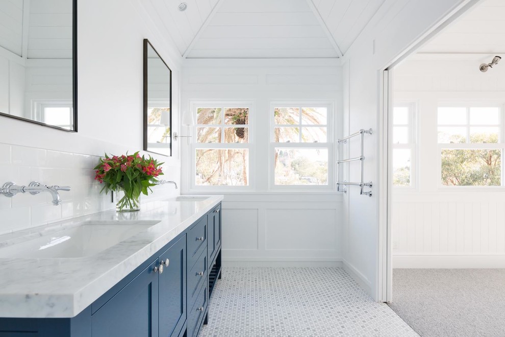 Aménagement d'une grande salle de bain principale classique avec un placard à porte shaker, des portes de placard bleues, un carrelage blanc, un carrelage métro, un mur blanc, un sol en marbre, un lavabo encastré, un plan de toilette en marbre, un sol gris et un plan de toilette gris.