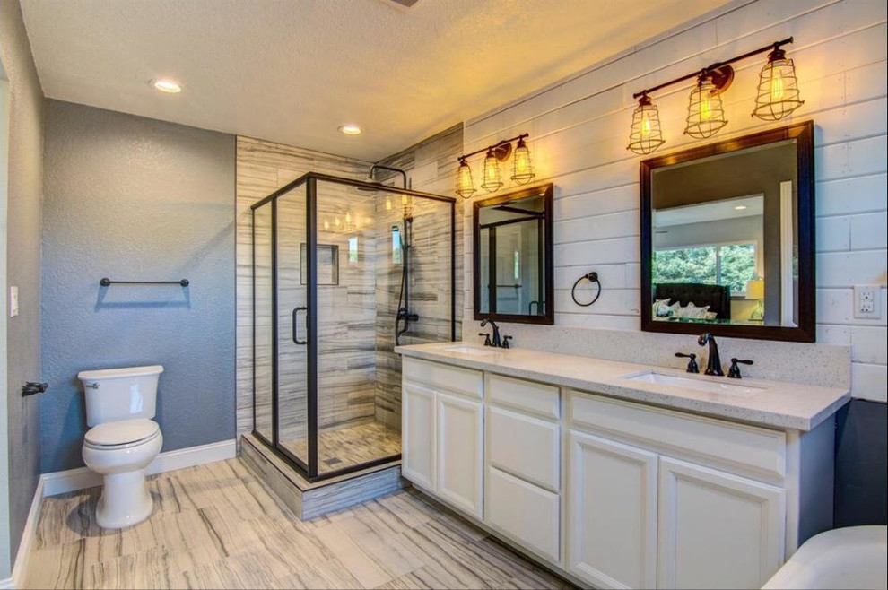 Идея дизайна: большая главная ванная комната в стиле неоклассика (современная классика) с фасадами с утопленной филенкой, белыми фасадами, отдельно стоящей ванной, угловым душем, унитазом-моноблоком, бежевой плиткой, керамогранитной плиткой, серыми стенами, полом из керамогранита, врезной раковиной, столешницей из искусственного кварца, бежевым полом и душем с распашными дверями