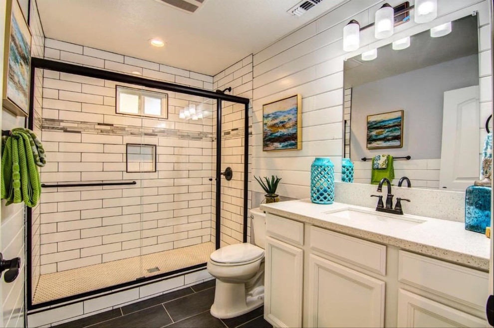Inspiration for a medium sized classic shower room bathroom in Sacramento with recessed-panel cabinets, white cabinets, an alcove shower, a two-piece toilet, white tiles, ceramic tiles, white walls, slate flooring, a submerged sink, grey floors and a sliding door.