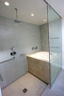 Cette photo montre une salle de bain moderne avec un bain japonais, une douche ouverte, WC suspendus, un carrelage en pâte de verre, un sol en calcaire et une vasque.