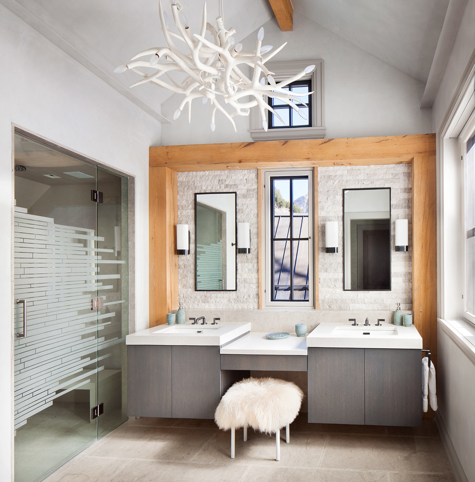Inspiration for a rustic bathroom in Denver with flat-panel cabinets, grey cabinets, an alcove shower, beige tiles, stone tiles, white walls, a submerged sink and a hinged door.