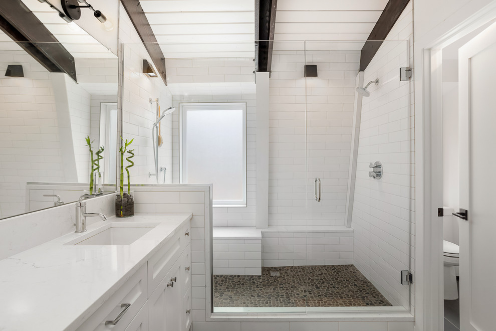 Design ideas for a medium sized contemporary ensuite bathroom in Portland with an alcove shower, a two-piece toilet, white walls, porcelain flooring, a submerged sink, grey floors, a hinged door, shaker cabinets, white cabinets, white tiles, metro tiles, quartz worktops and white worktops.