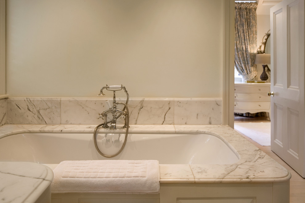 Traditional bathroom in London with a built-in bath and white tiles.
