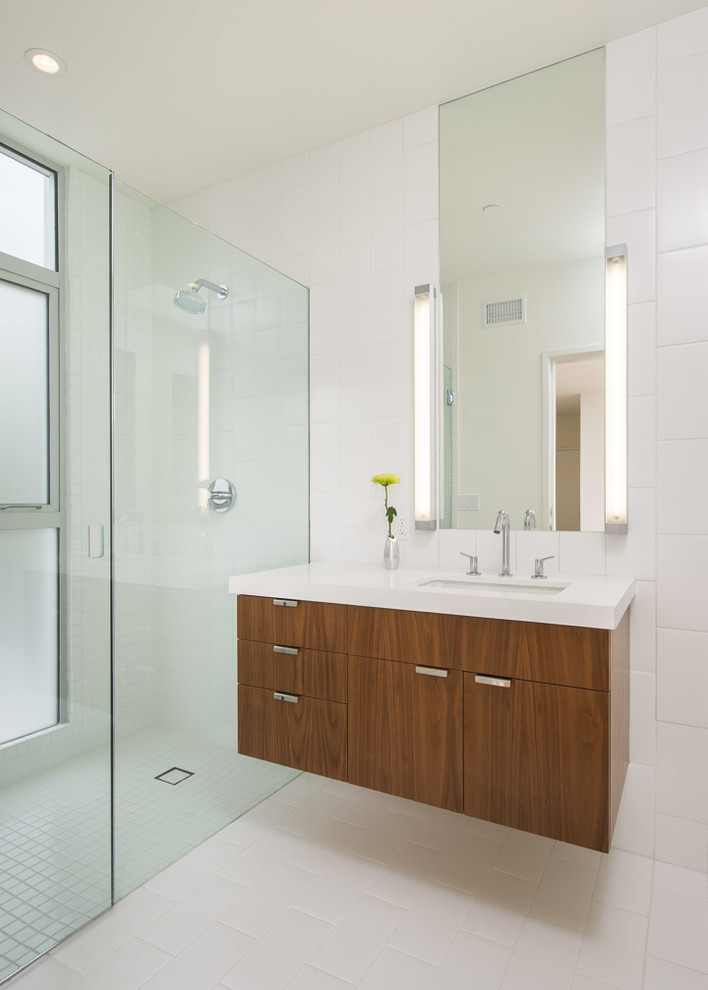 Modernes Badezimmer mit Unterbauwaschbecken, flächenbündigen Schrankfronten, dunklen Holzschränken, Quarzwerkstein-Waschtisch, bodengleicher Dusche, weißen Fliesen, Keramikfliesen, weißer Wandfarbe und Keramikboden in Los Angeles