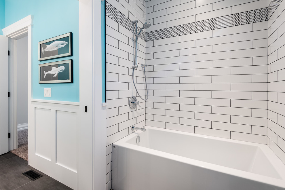 Cette photo montre une salle de bain chic de taille moyenne pour enfant avec un placard à porte shaker, des portes de placard blanches, une baignoire en alcôve, un carrelage blanc, un carrelage métro, un mur bleu, un sol en carrelage de porcelaine et un plan de toilette en granite.
