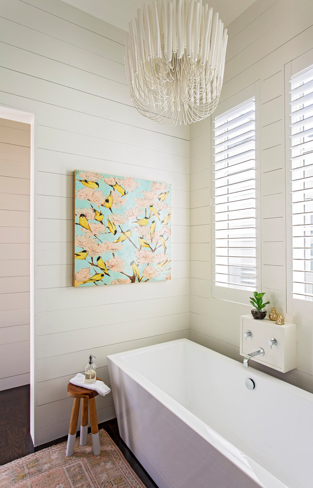 Cette image montre une salle de bain traditionnelle avec une baignoire indépendante, un mur blanc, parquet foncé, un sol marron et du lambris de bois.