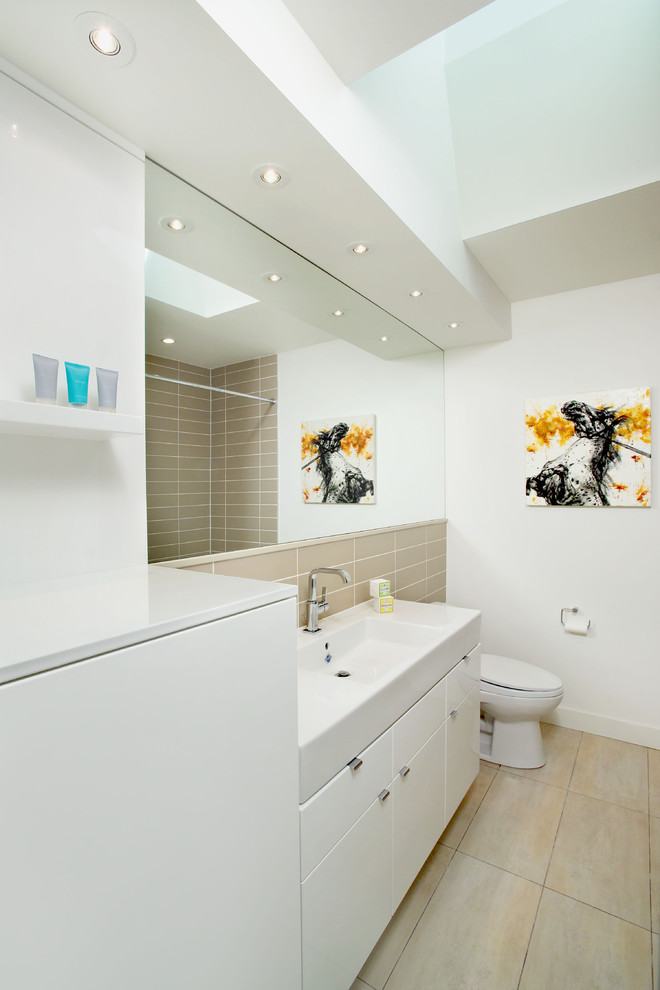 Идея дизайна: ванная комната в современном стиле с монолитной раковиной, плоскими фасадами, белыми фасадами, бежевой плиткой, плиткой кабанчик, ванной в нише, душем над ванной, раздельным унитазом и полом из керамогранита