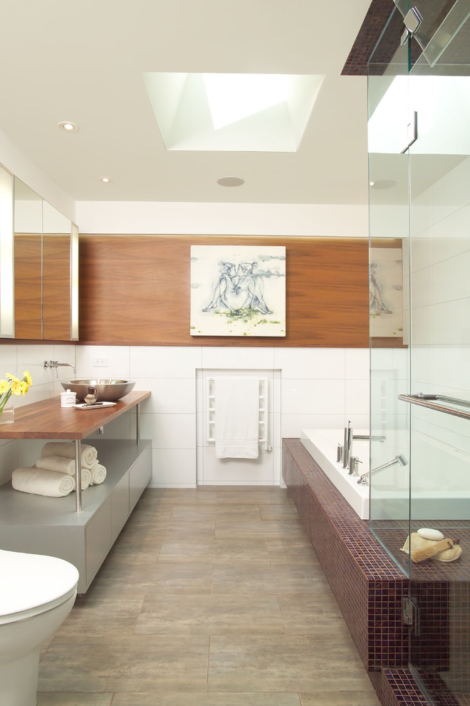 Idee per una stanza da bagno contemporanea con lavabo a bacinella, top in legno, vasca da incasso, piastrelle bianche, WC monopezzo e pavimento in gres porcellanato