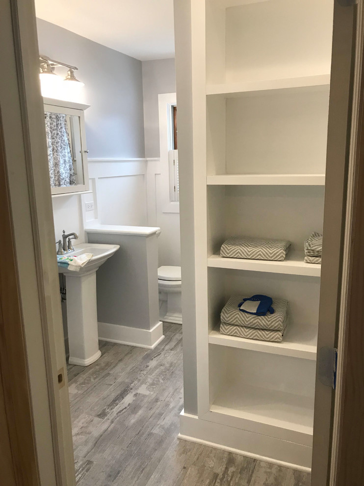 Large traditional shower room bathroom in Chicago with a two-piece toilet, grey walls, medium hardwood flooring, a pedestal sink, brown floors and white worktops.