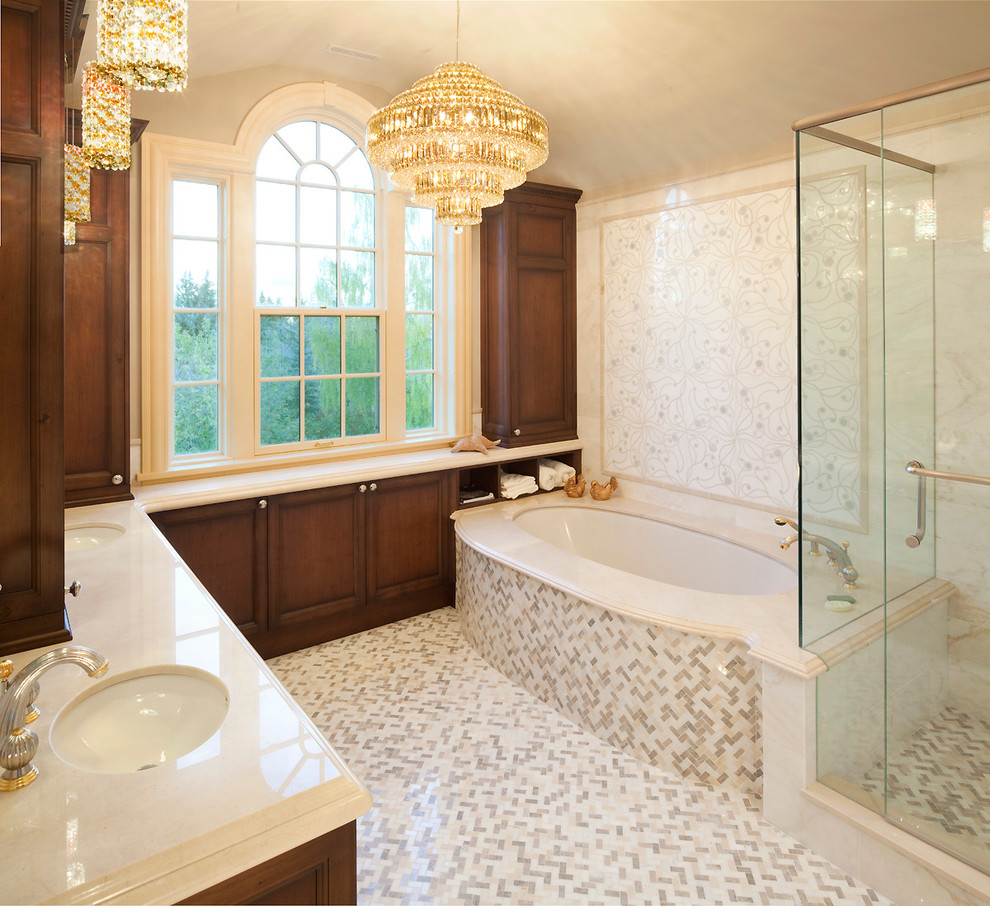 Стильный дизайн: большая главная ванная комната в классическом стиле с фасадами с утопленной филенкой, фасадами цвета дерева среднего тона, полновстраиваемой ванной, угловым душем, раздельным унитазом, бежевыми стенами и врезной раковиной - последний тренд