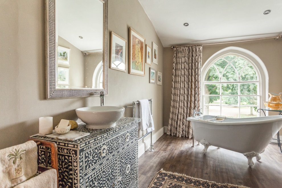 This is an example of a medium sized classic bathroom in Other with a claw-foot bath, brown walls, dark hardwood flooring, a vessel sink, brown floors and flat-panel cabinets.