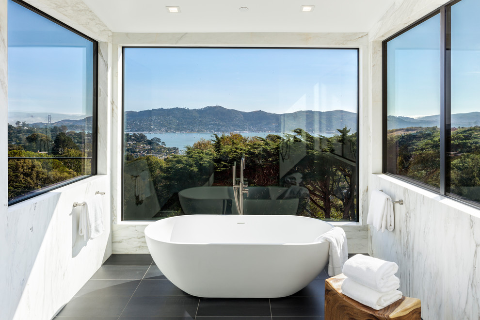 Стильный дизайн: большая главная ванная комната в современном стиле с отдельно стоящей ванной, белой плиткой, плиткой из листового камня, полом из керамогранита и черным полом - последний тренд