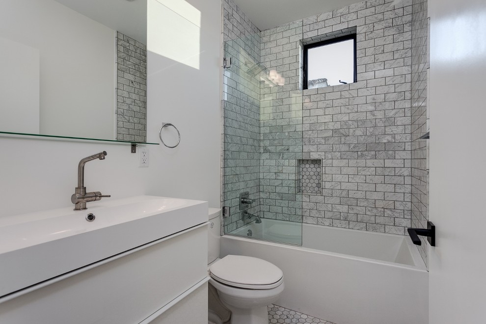 Idéer för mellanstora funkis en-suite badrum, med ett väggmonterat handfat, skåp i shakerstil, vita skåp, marmorbänkskiva, en dusch i en alkov, en toalettstol med hel cisternkåpa, vit kakel, kakel i småsten, vita väggar, mosaikgolv och ett badkar i en alkov