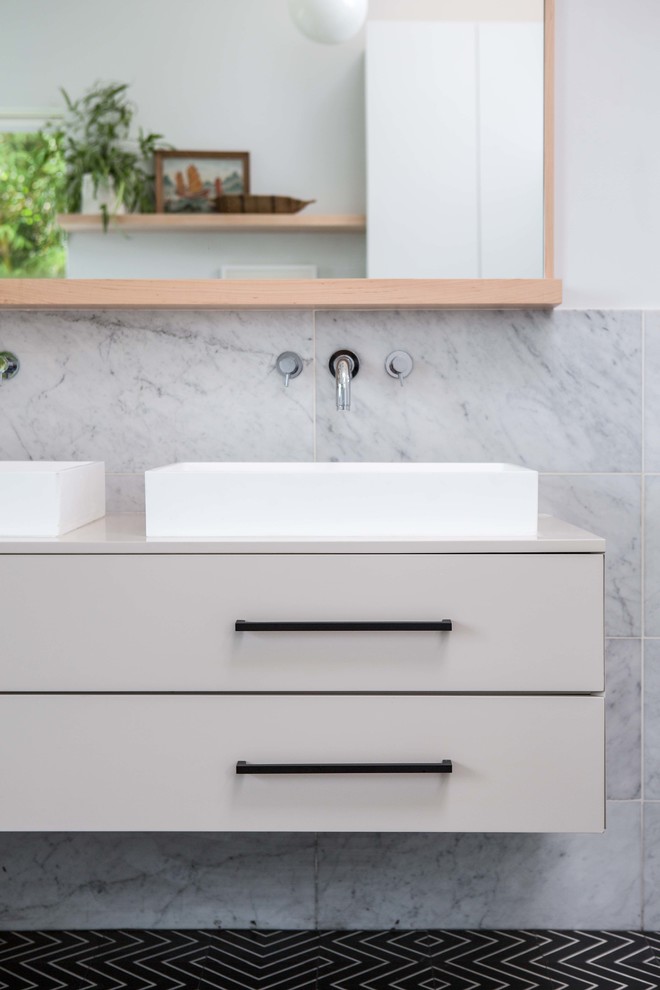 Inspiration for a large modern kids' white tile and marble tile cement tile floor and black floor bathroom remodel in Los Angeles with flat-panel cabinets, beige cabinets, a two-piece toilet, white walls and a vessel sink