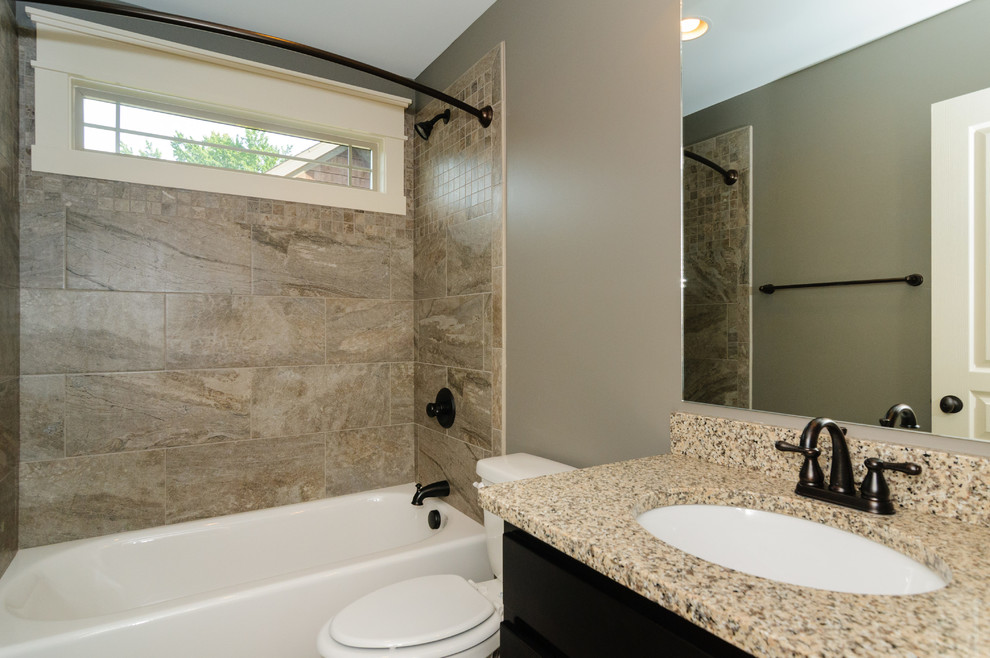 Inspiration for a medium sized traditional shower room bathroom in Other with raised-panel cabinets, black cabinets, a corner bath, a walk-in shower, a one-piece toilet, beige tiles, black tiles, white tiles, stone tiles, beige walls, dark hardwood flooring, a built-in sink, soapstone worktops and an open shower.