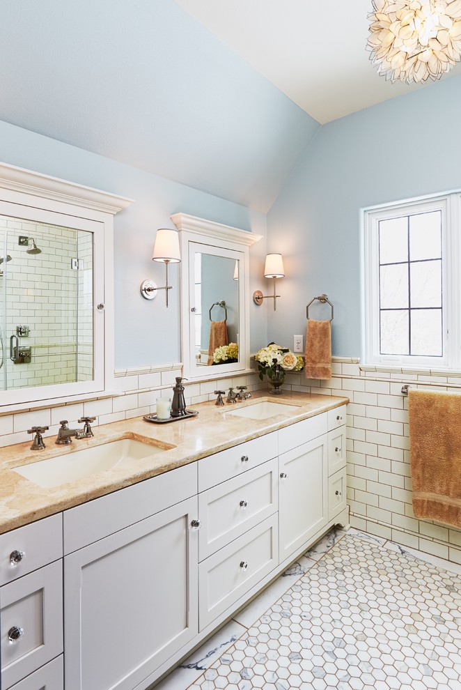 ミルウォーキーにあるトランジショナルスタイルのおしゃれな浴室 (アンダーカウンター洗面器、シェーカースタイル扉のキャビネット、白いキャビネット、白いタイル、青い壁、サブウェイタイル、大理石の床) の写真