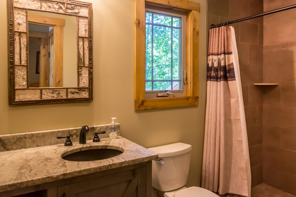 Foto på ett litet rustikt brun badrum, med skåp i shakerstil, bruna skåp, en dusch i en alkov, en toalettstol med separat cisternkåpa, beige kakel, keramikplattor, beige väggar, ett undermonterad handfat, granitbänkskiva och dusch med duschdraperi