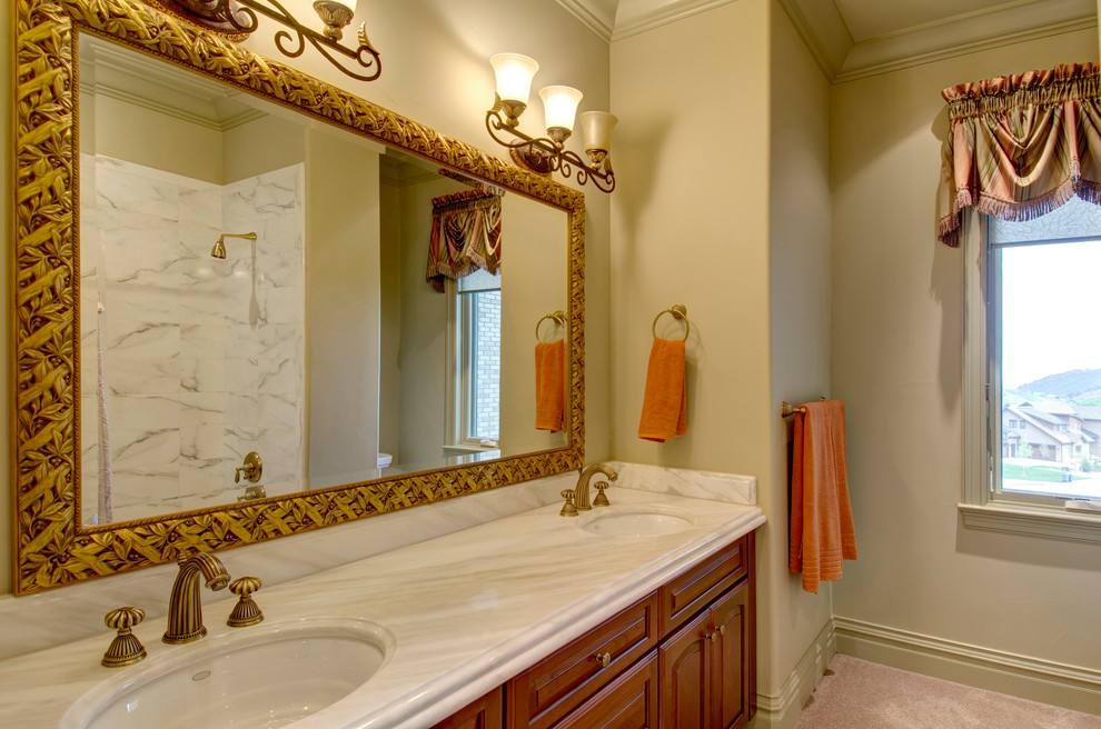 Идея дизайна: большая главная ванная комната в викторианском стиле с фасадами с выступающей филенкой, фасадами цвета дерева среднего тона, полновстраиваемой ванной, душем над ванной, унитазом-моноблоком, коричневыми стенами, врезной раковиной, мраморной столешницей, бежевым полом и шторкой для ванной
